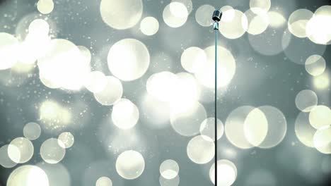 Retro-metallic-microphone-against-spots-of-light-against-grey-background
