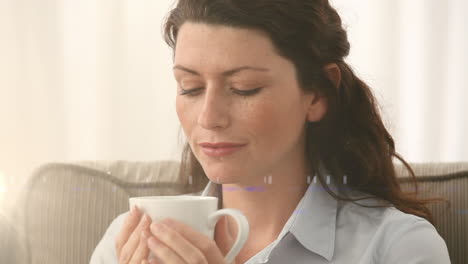animación de puntos de luz sobre una mujer caucásica bebiendo café en casa