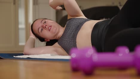 young caucasian woman doing floor exercises at home during lockdown 2020