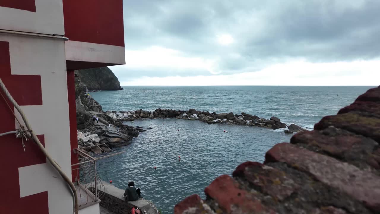 이탈리아 리오마지오레 마을에서 바다를 내려다보는 느리게 움직이는 비디오 시스는 벽 너머의 바다 풍경을 보여주며 평온한 해안의 아름다움을 포착합니다.