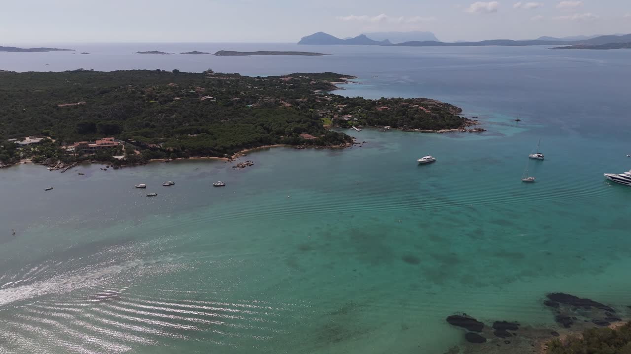drone reveals scenic seascape in costa Esmeralda Sardinia Italy travel destination cala di volpe luxury yacht moored at bay scenic seascape view
