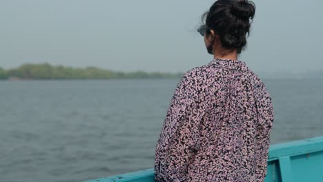 South-Asian-woman-enjoying-freedom-on-deck-in-the-wind-relaxing-on-high-end-boat-summer-vacation-trip