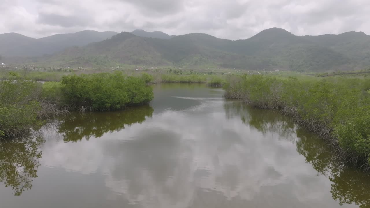 sobrevuelo aéreo de un río que va al océano con montañas al fondo en sierra leona, áfrica