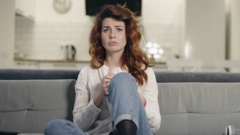 Upset-woman-watching-tv-at-open-kitchen.-Closeup-depressed-woman-wiping-face