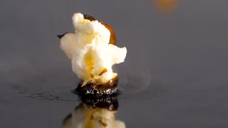 popcorn kernel pops in slow motion, cooks on heat, splits and bursts open, close up