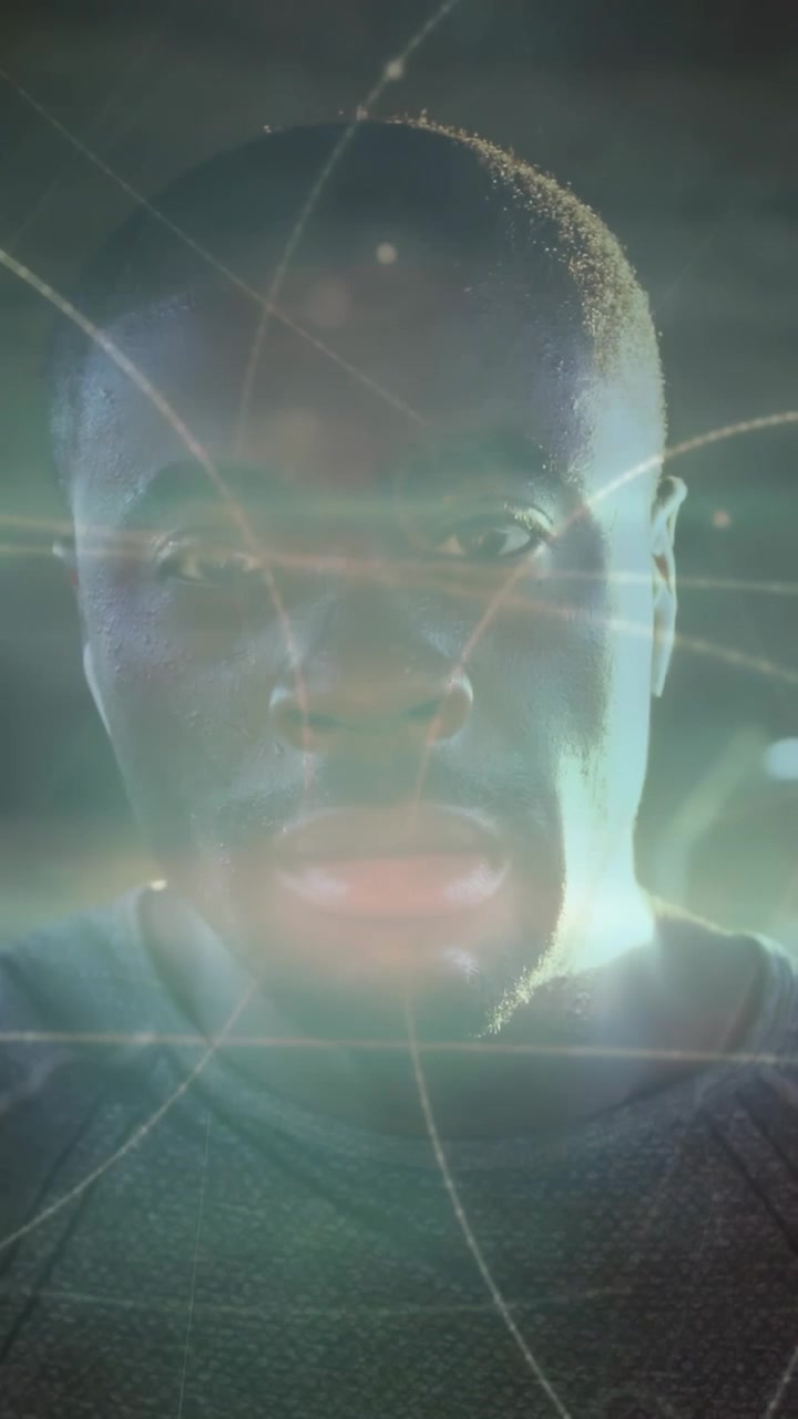 Vidéo verticale : Un homme lève l'avant-bras, joint et abaisse les bras face à la caméra, un HUD technologique guidant la mise au point.