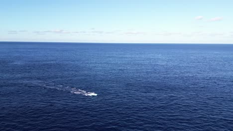 a boat travels across the calm blue ocean under a clear sky.