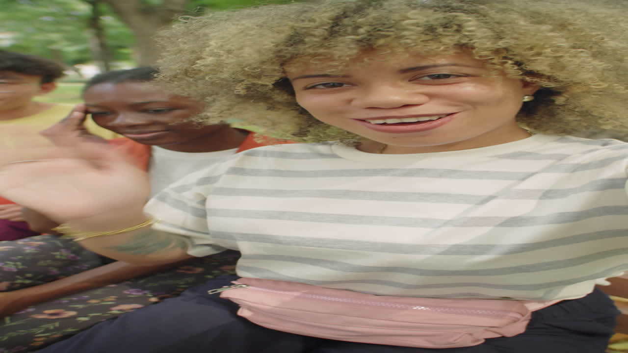 Joyous Friends Waving and Speaking on Camera in Park