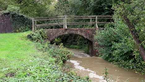 el río gwash que fluye a través del pueblo de braunston en rutland fuertemente hinchado después de fuertes lluvias