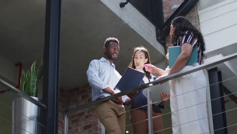 Focused-diverse-group-of-business-people-working-together,-discussing-work-in-modern-office