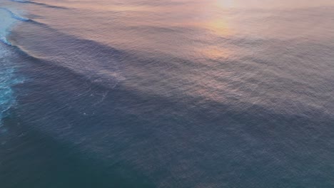 Clip-Aéreo-De-Drones-De-Olas-Oceánicas-Que-Reflejan-La-Puesta-De-Sol-Dorada