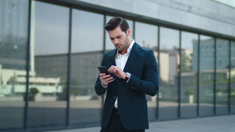 closeup businessman reading bad news at street. businessman using smartphone