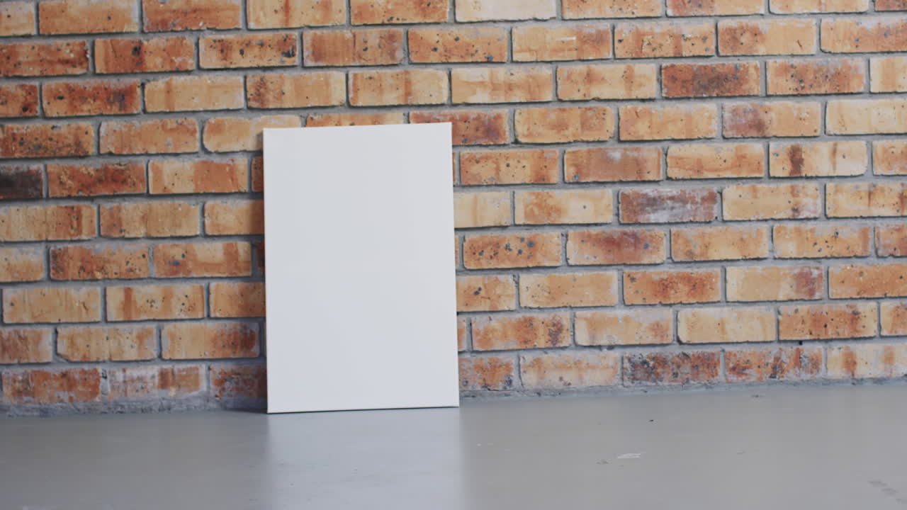 Video of white canvas sign with copy space on floor against brick wall background