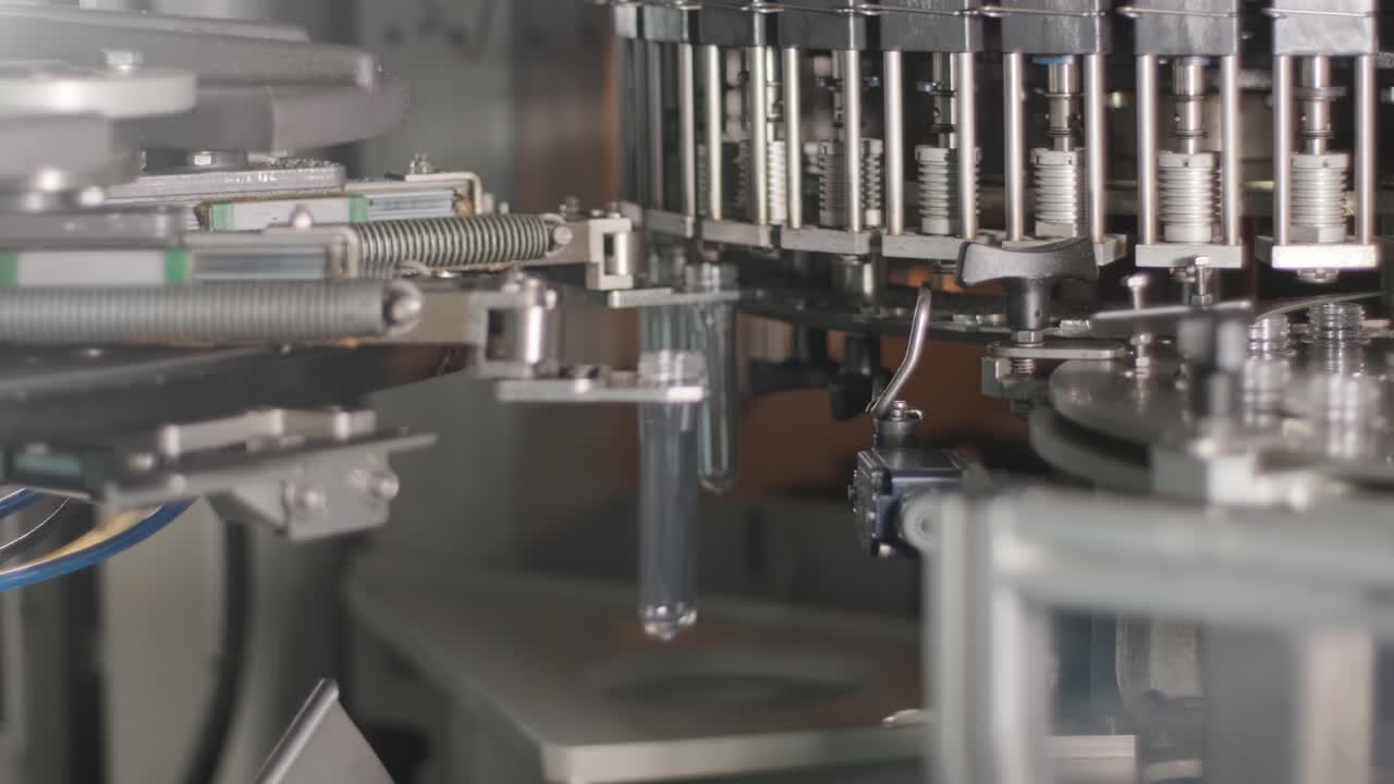 Automatic filling machine pours water into plastic PET bottles at modern beverage plant