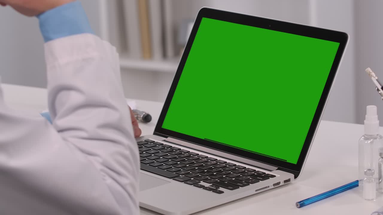 pantalla verde chroma clave concepto de portátil: diagnóstico de examen a distancia remoto en línea por videoconferencia. hombre médico consulta al paciente explica el tratamiento por cámara web. cerca. cámara lenta