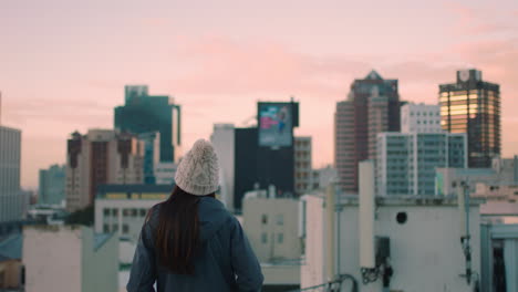 Junge-Frau-Auf-Dem-Dach-Bei-Sonnenuntergang-Und-Genießt-Den-Wunderschönen-Blick-Auf-Die-Skyline-Der-Stadt