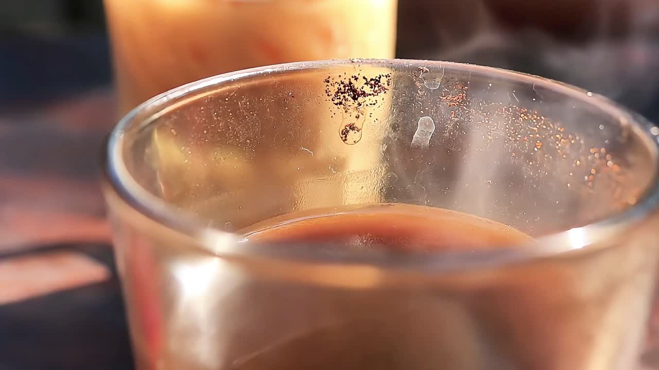 Close up video of a steaming hot coffee cup placed on a wooden table, perfect for café lifestyle, breakfast mood, food and beverage, relaxation and cozy morning vibes