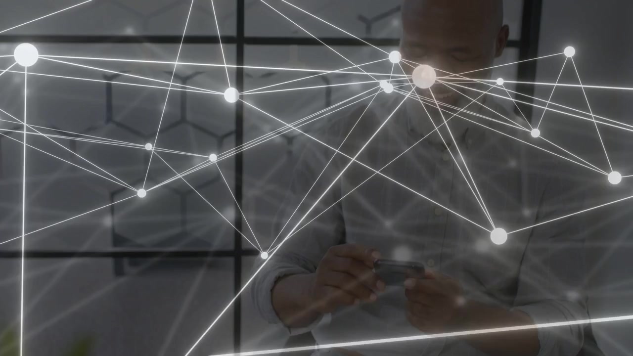 Businessman leaning into handheld device, tapping and reviewing charts while animated net sweeping
