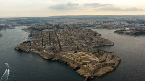 aerial tilt shot in front of the fort saint elmo and the valletta cityscape, sunset in malta