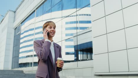 donna d'affari che parla al telefono e beve caffè