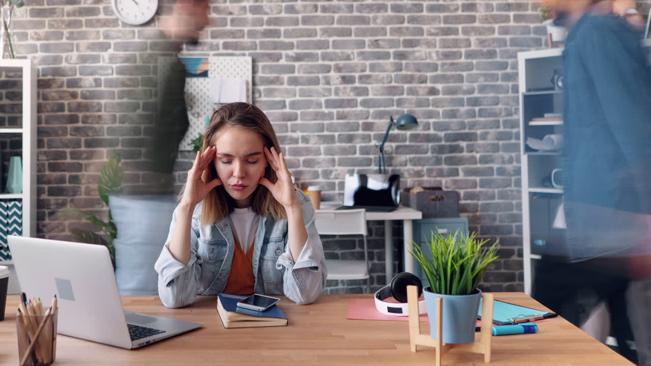 Stressed woman in a busy office