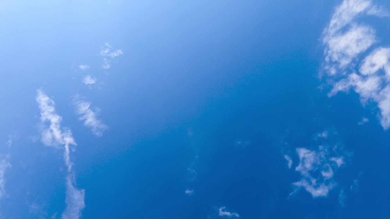 Blue skies clearing up from white clouds. Cloudscape formation in the horizon timelapse. View from below.