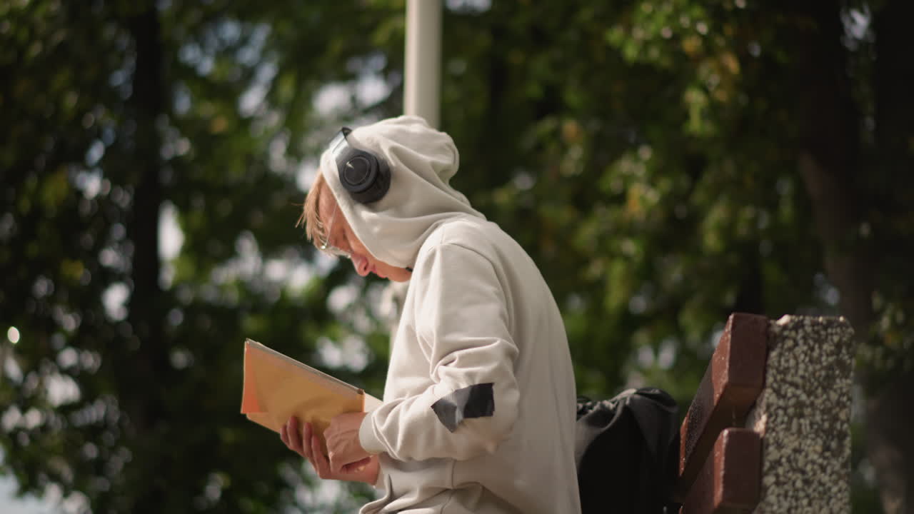パーカーを着た読書好きが公園のベンチでメモを読み込み、詩人が行を編集し、通勤者がスケジュールを確認し、旅行者がルートを地図に落とし、研究者が木漏れ日の当たる街灯の下で余白に注釈を入れている様子。