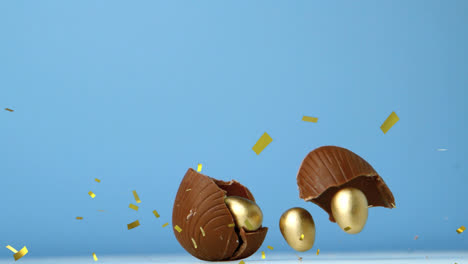 animation of gold confetti over chocolate easter egg breaking, with gold eggs inside, on blue