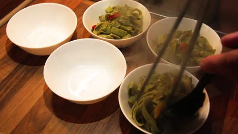 homemade cook puts prepared food into bowls