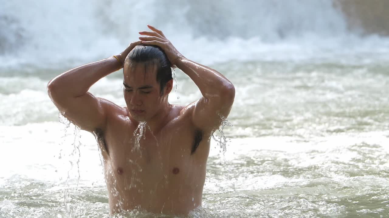 Man enjoying a refreshing swim in a waterfall
