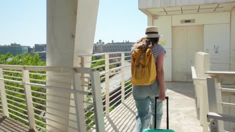 woman in summer hat walking through airport walkway
