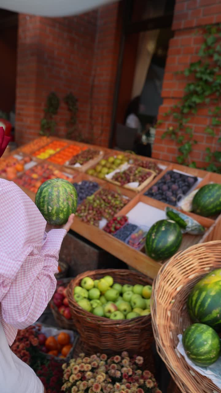mujer comprando frutas frescas en un mercado al aire libre