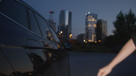 Manos-Femeninas-Enchufando-El-Cargador-En-Un-Coche-Eléctrico,-Primer-Plano