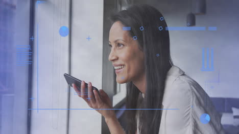 animación del procesamiento de datos financieros sobre una mujer de negocios biracial usando un teléfono inteligente en la oficina.