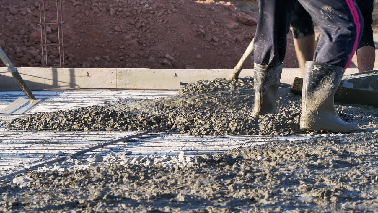 건설 노동자 들 이 시멘트 와 자갈 을 어서 동남아시아 에서 건설 중 인 건물 의 바닥 에 어 놓고 있다