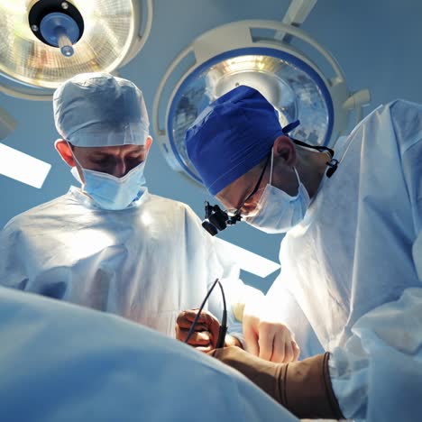 medical specialists in modern operating room. doctors perform a surgery and looking on the process on the monitor