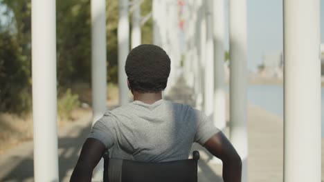 Rear view of African American man using wheelchair walking