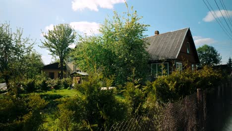 a cozy brown wooden summerhouse surrounded by a lush green garden during spring