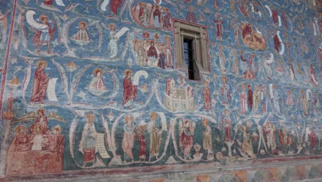 detail of murals on blue shade walls at voronet monastery in suceava, romania