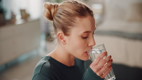 young woman drinking water after a workout