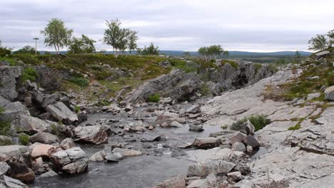 ruta de senderismo cruzando un pequeño río en la zona ártica del norte de noruega