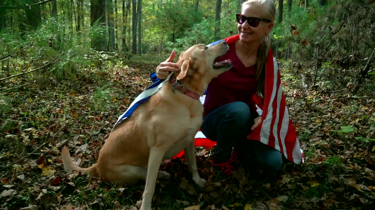 Woman and Dog with American Flag in Forest