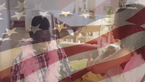Animation-of-flag-of-usa-waving-over-african-american-couple-talking-and-smiling