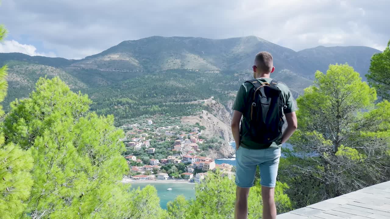 Yunanistan'da bir sahil köyünün nefes kesen manzarasının tadını çıkaran yürüyüşçü