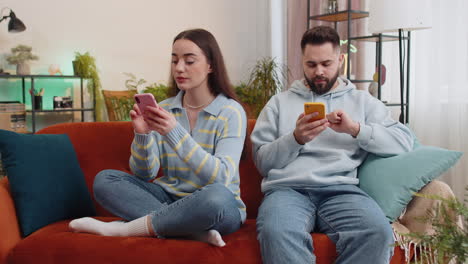 Family-marriage-couple-man-woman-using-smartphones-after-argument-quarrel-at-home,-ignore-each-other