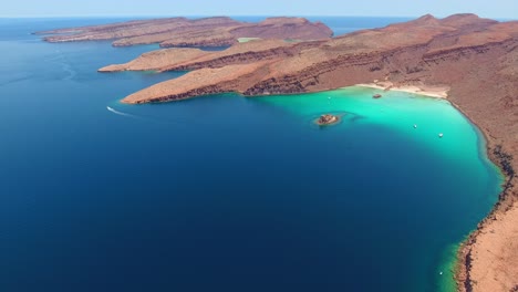 slow forward flight of unique desert island cliffs and amazing water scenery with speeding powerboat in the distance