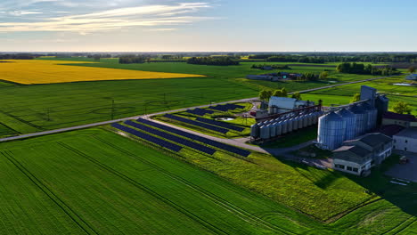 rural environment merging crop fields and renewable energy facility. drone panning left