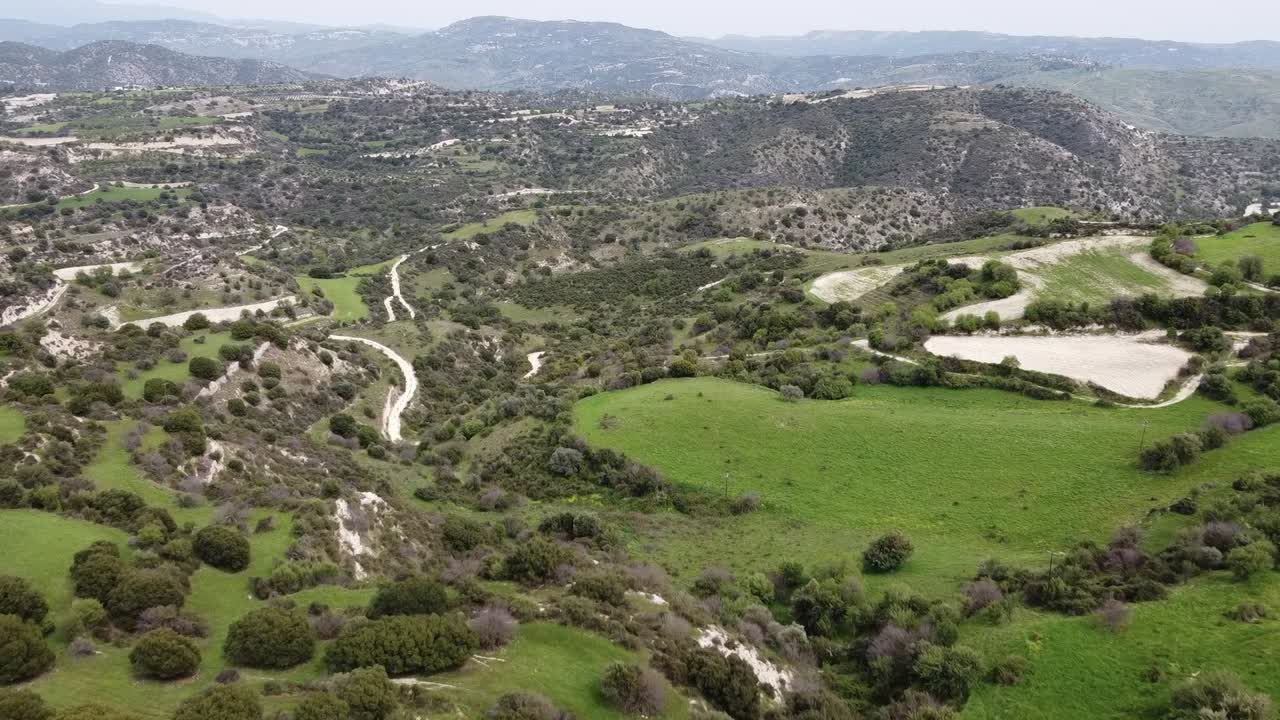 Explore the beautiful landscape of rolling hills and lush greenery in the countryside. The sunny day highlights winding paths and vibrant vegetation, creating a serene atmosphere