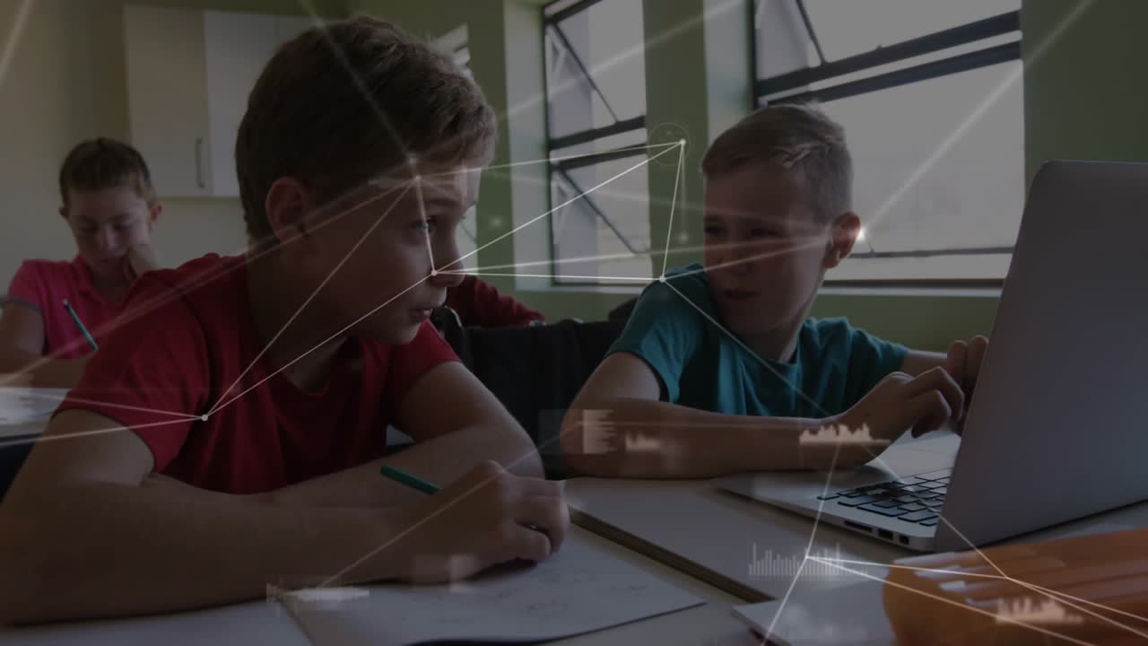 Two boys in classroom, teal boy typing on laptop drawing red boy writing amid network overlay