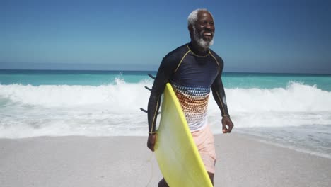 Senior man running with a surfboard